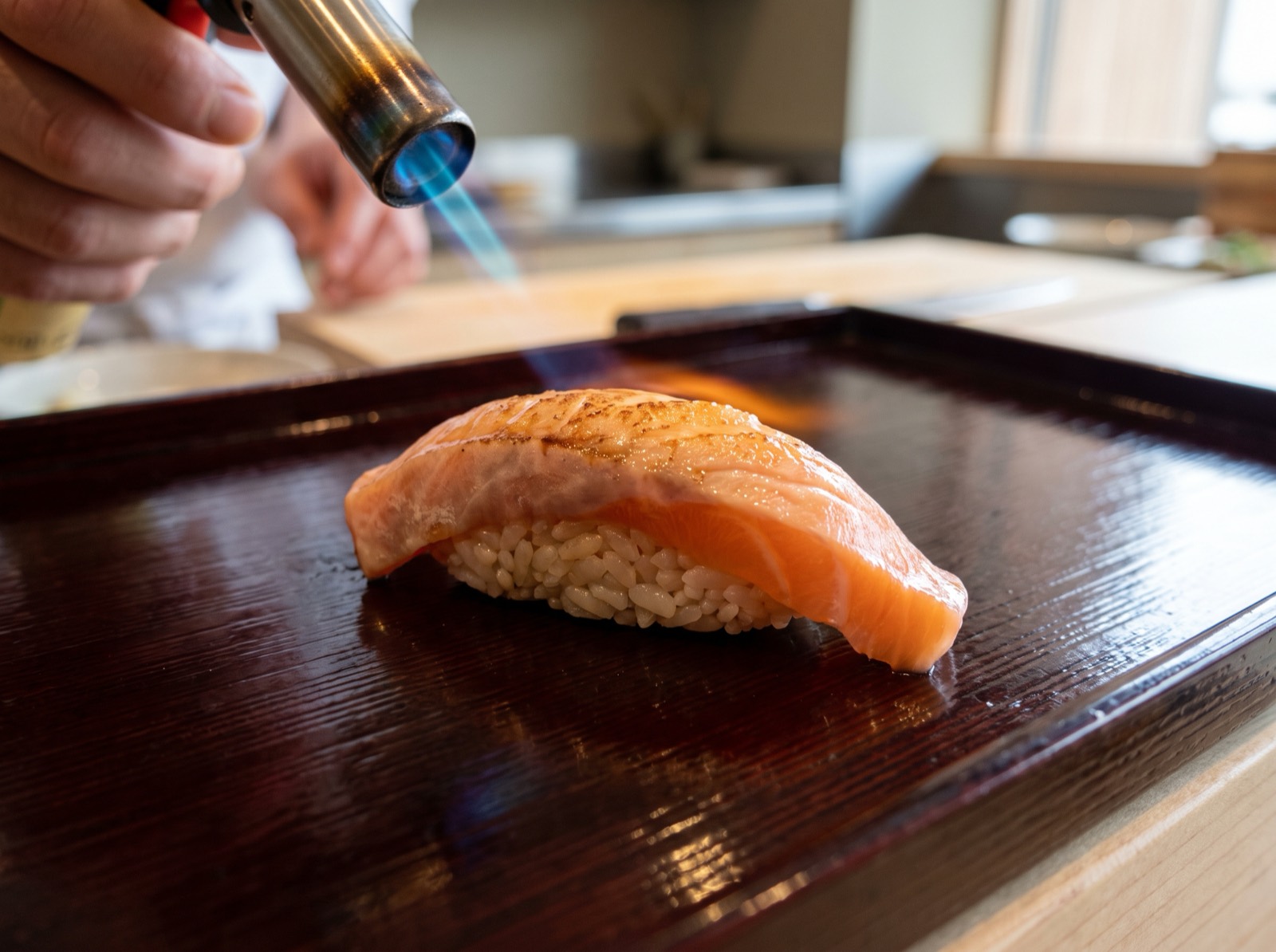Aburi nigiri, a torch flame caught mid-pass grazing only the surface.