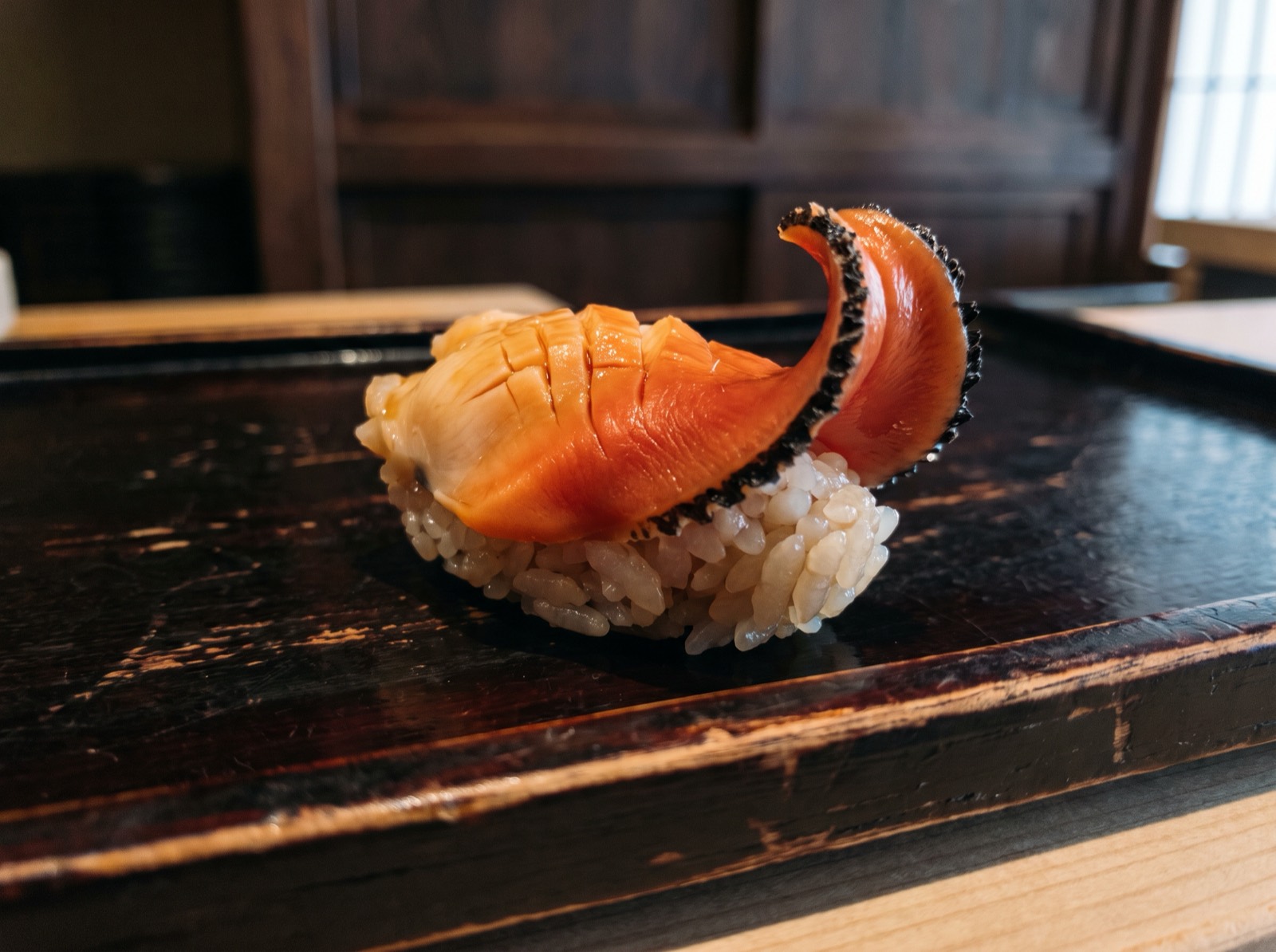Ark shell nigiri, scored so the flesh curls back.