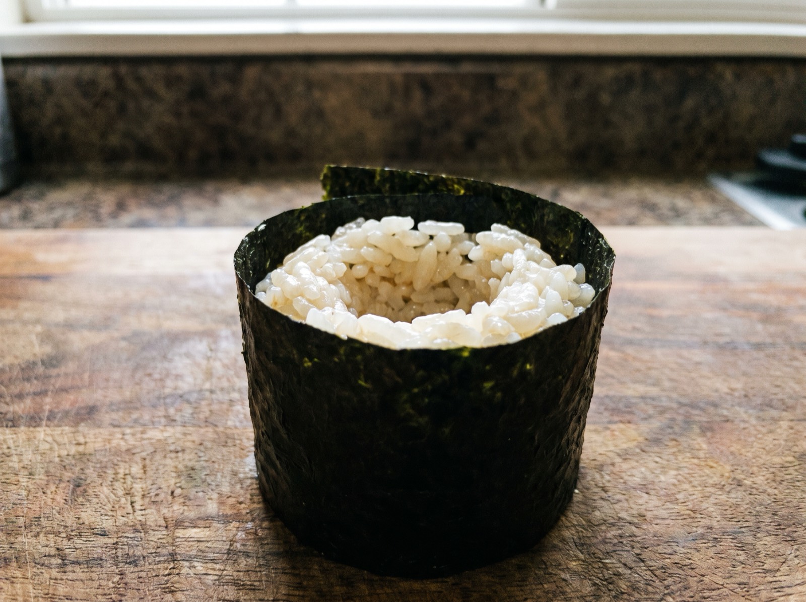 Gunkan, an empty nori-wrapped shell with nothing inside yet.