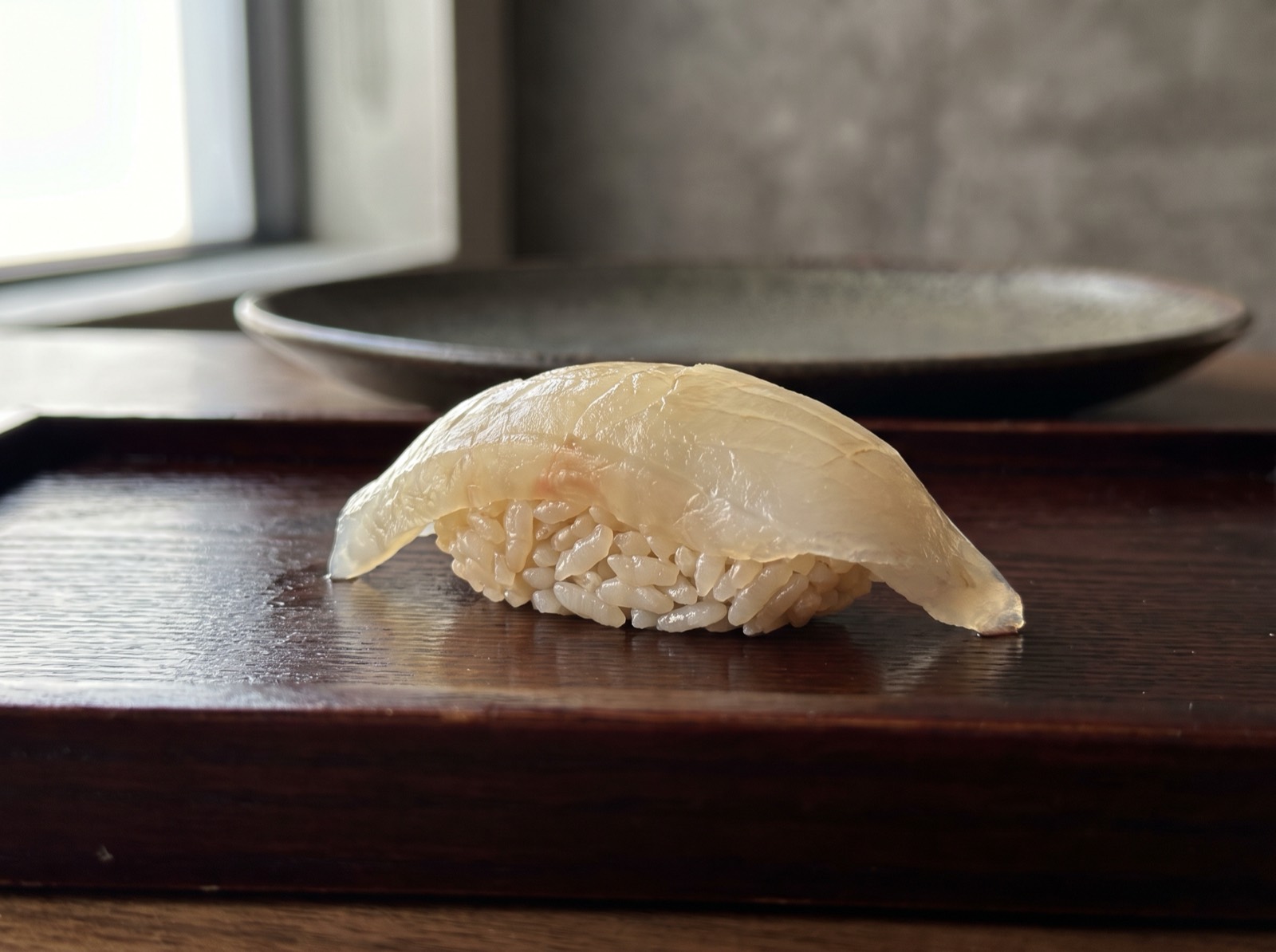 Flounder nigiri, sliced thin enough to show the rice through it.