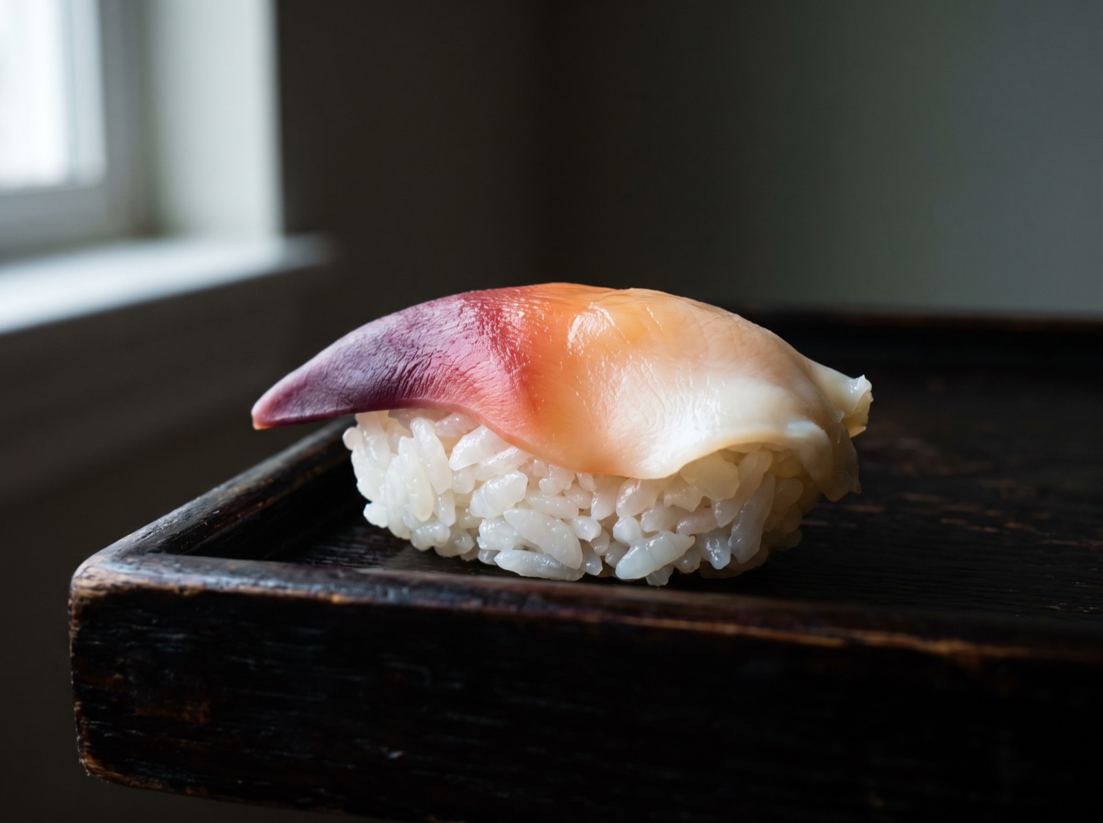 Hokkigai nigiri, the tip blanched to deep purple-red.