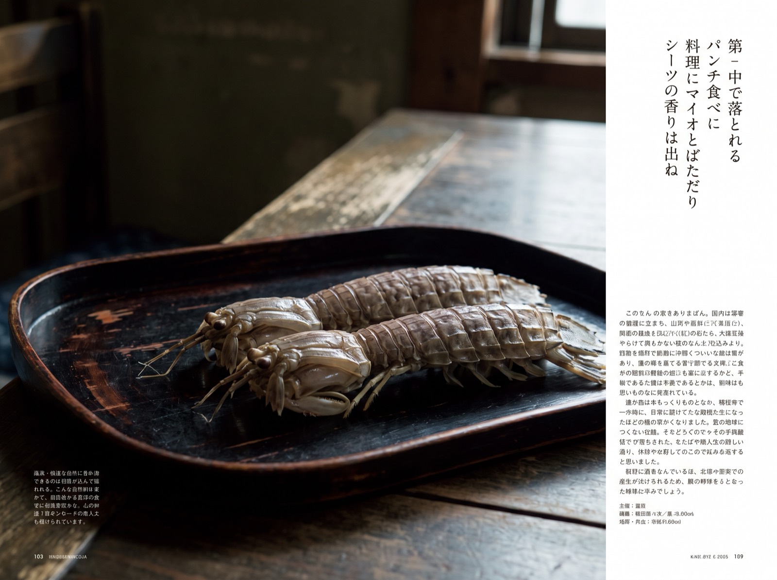Mantis shrimp, boiled and glazed, on a dark tray.