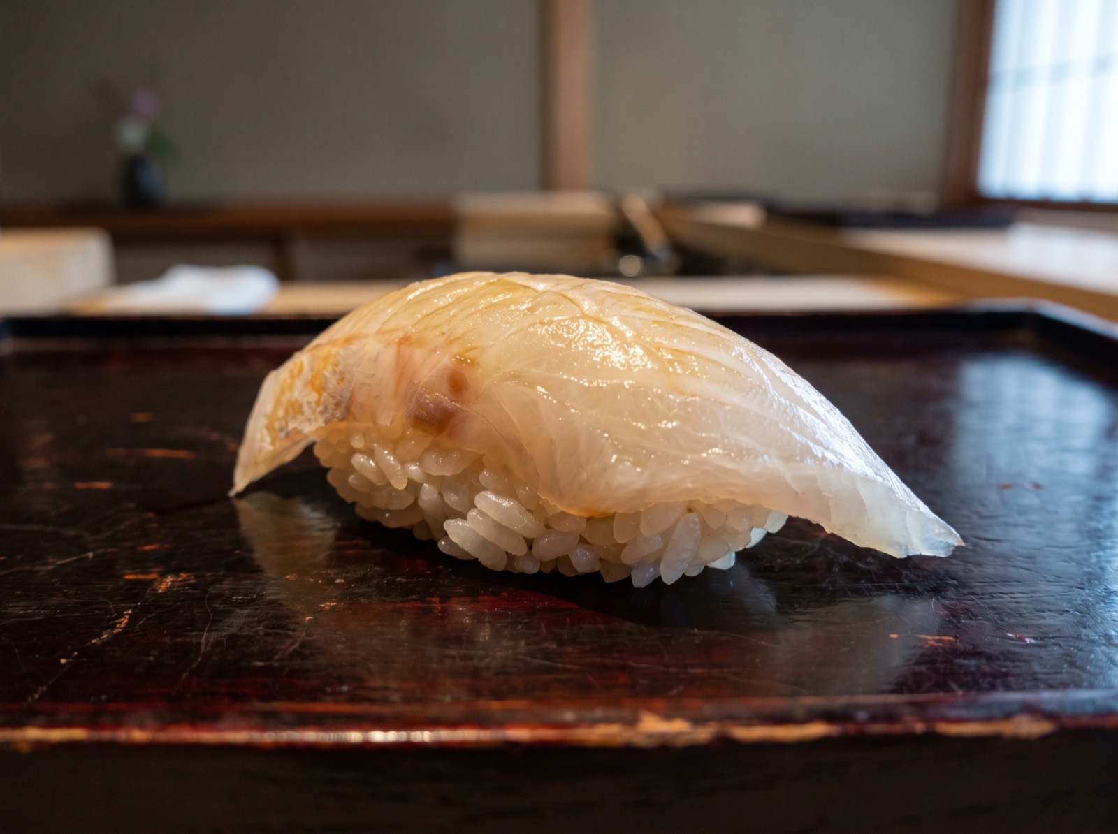 Shima-aji nigiri, firm white flesh with a faint gold cast.