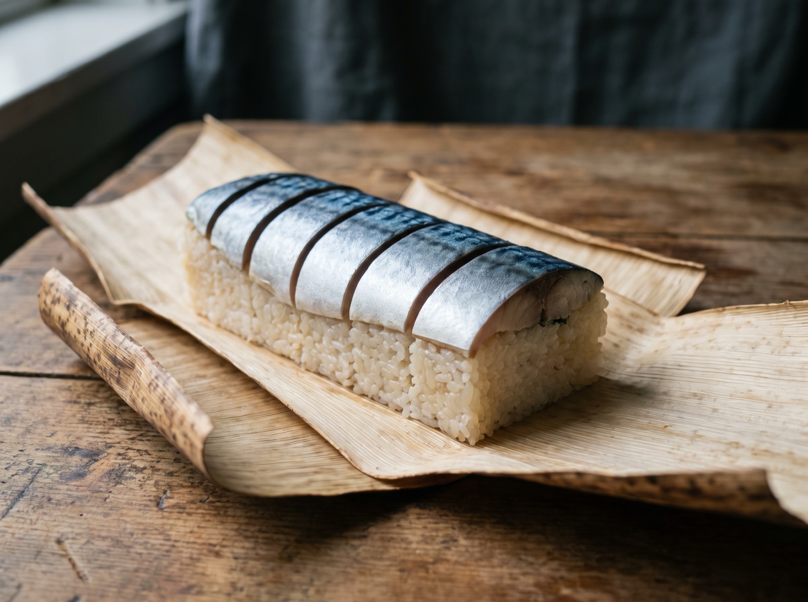 Saba sushi, sliced and laid on bamboo bark.