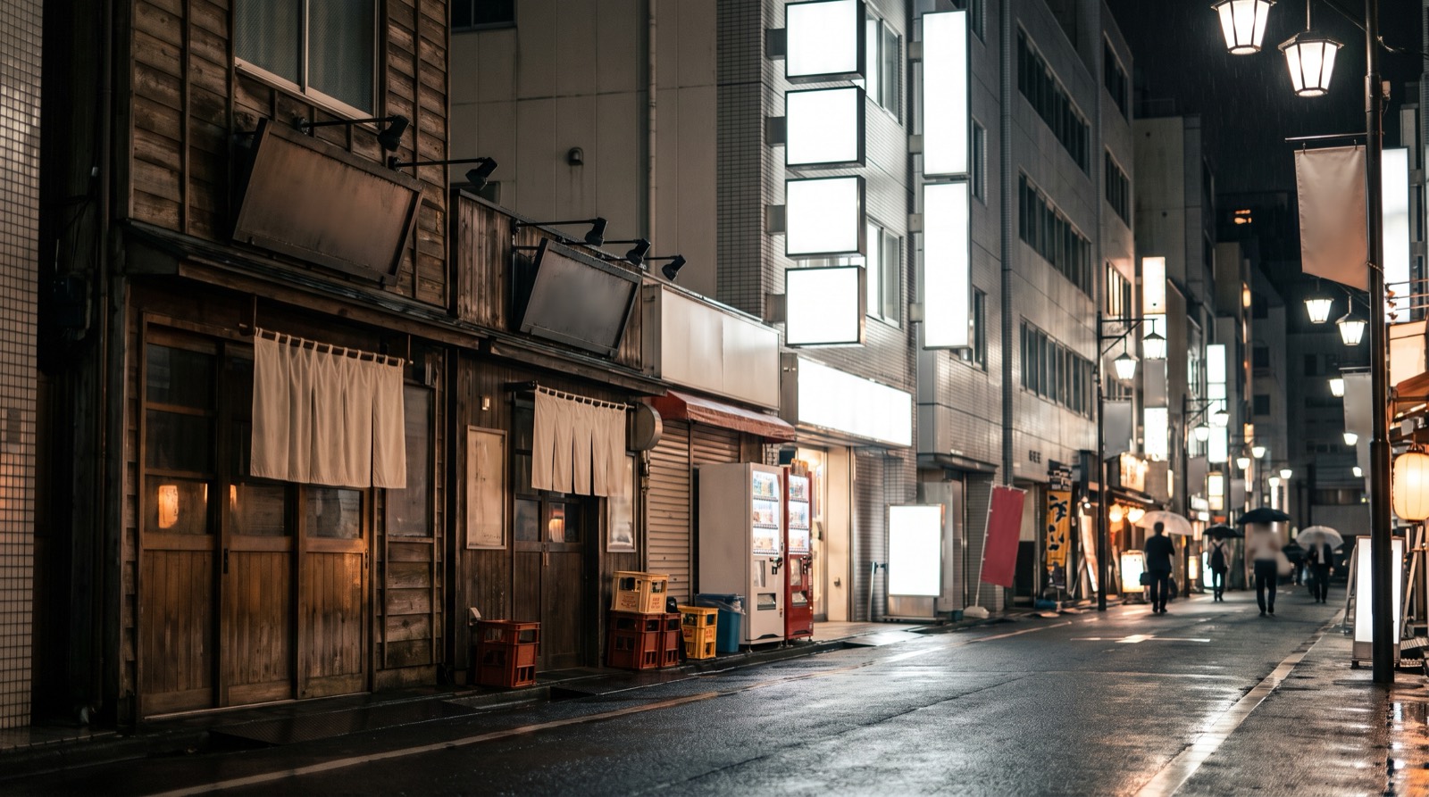 A night street where small independent frontages give way to tall stacked signage.