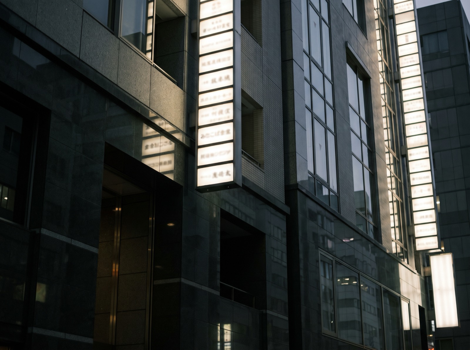 Looking up at a multi-tenant city building whose ground floor holds no restaurant.